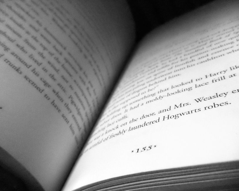Close-up view of an open book, focusing on text and page 155.