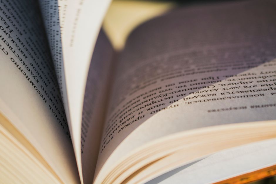 Detailed close-up image of an open book showing the textured pages and printed text.